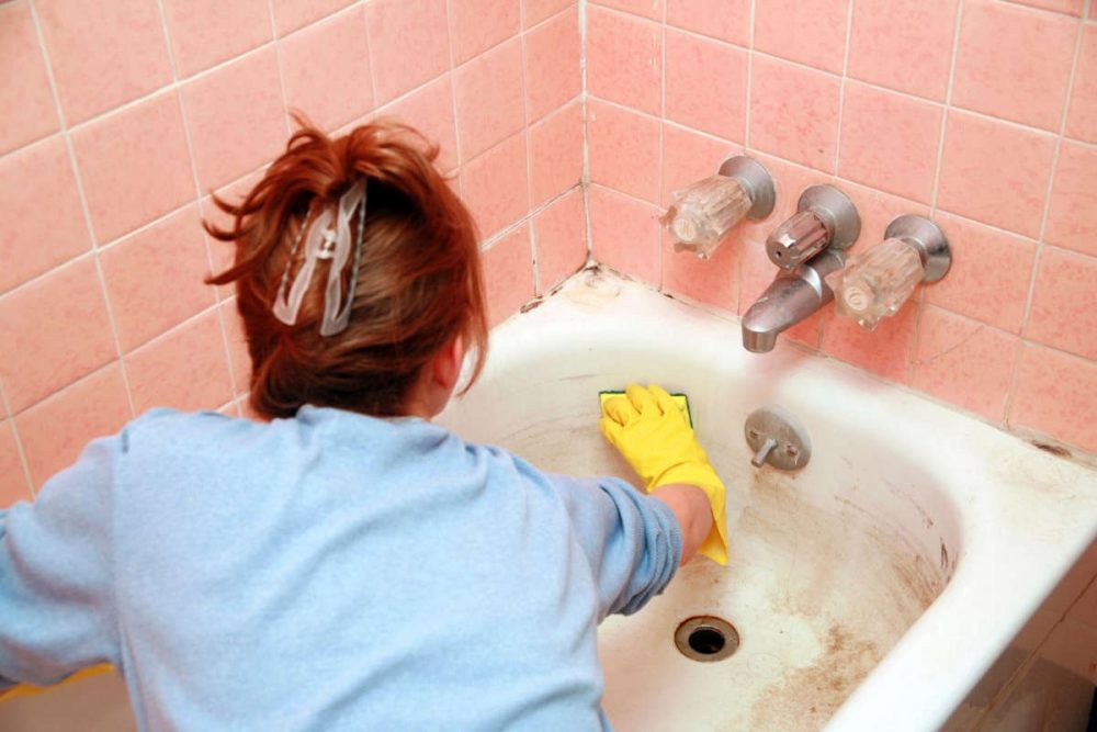 Женщина чистит ванну